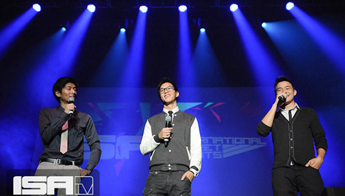 Three young men on stage at an ISA Live event